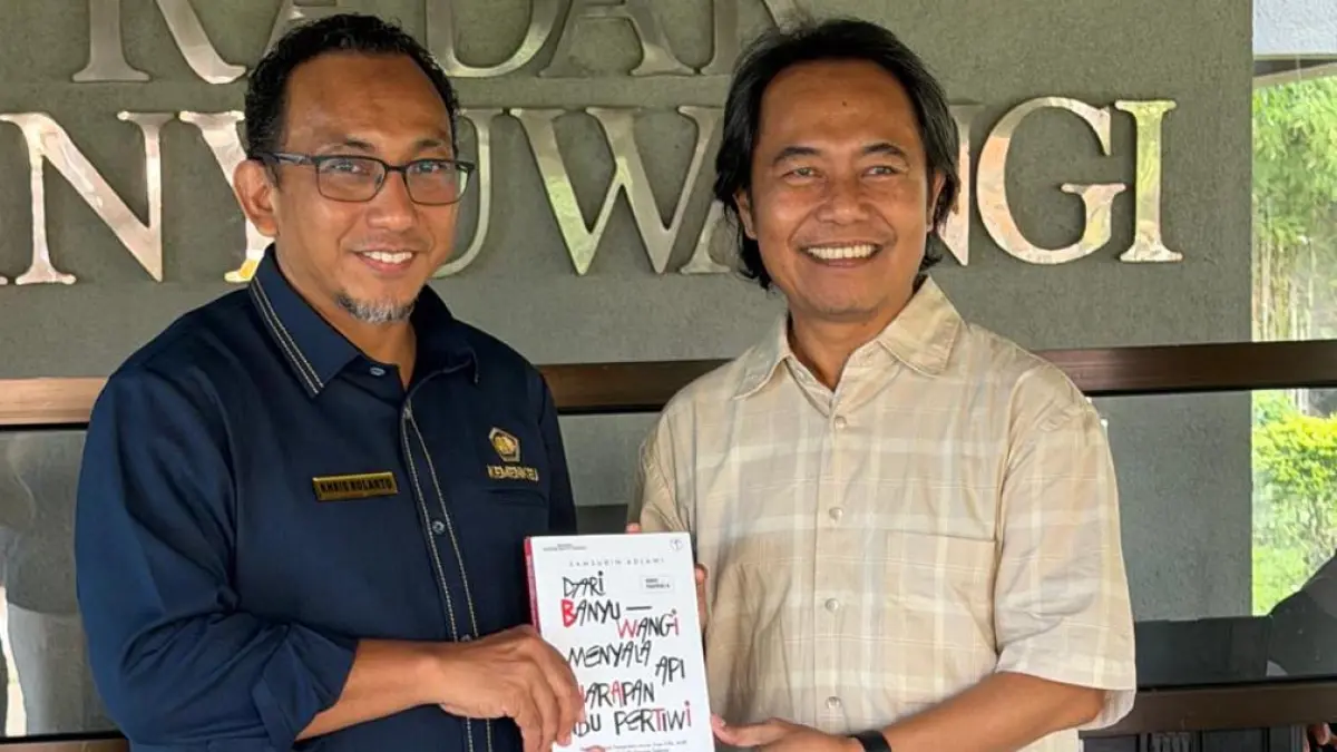 BUAH TANGAN: Kepala KPP Pratama Banyuwangi Khris Rolanto (kiri) menerima buku Man Nahnu 6 dari sang penulis yang sekaligus Direktur JP-RaBa Samsudin Adlawi di gedung Grha Pena Banyuwangi, Rabu (15/4). (Syaifuddin Mahmud/Radar Banyuwangi)