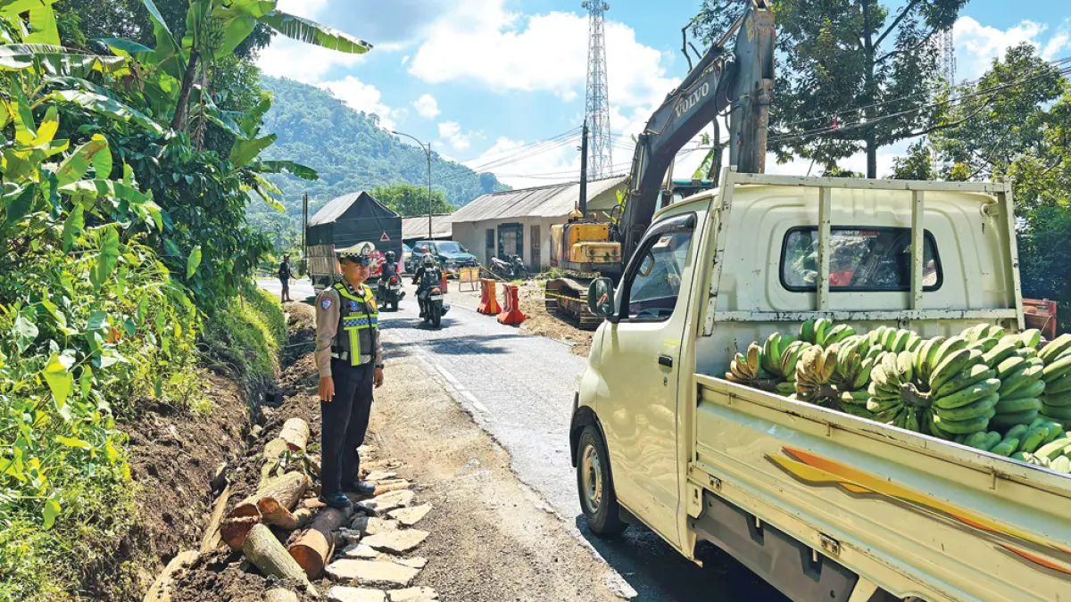 REKAYASA LALIN: Anggota Polsek Kalibaru melakukan pengamanan arus lalu lintas di jalur Gumitir, Dusun Barurejo, Desa Kalibarumanis, Kecamatan Kalibaru, Rabu (15/4). (Salis Ali/Radar Banyuwangi)