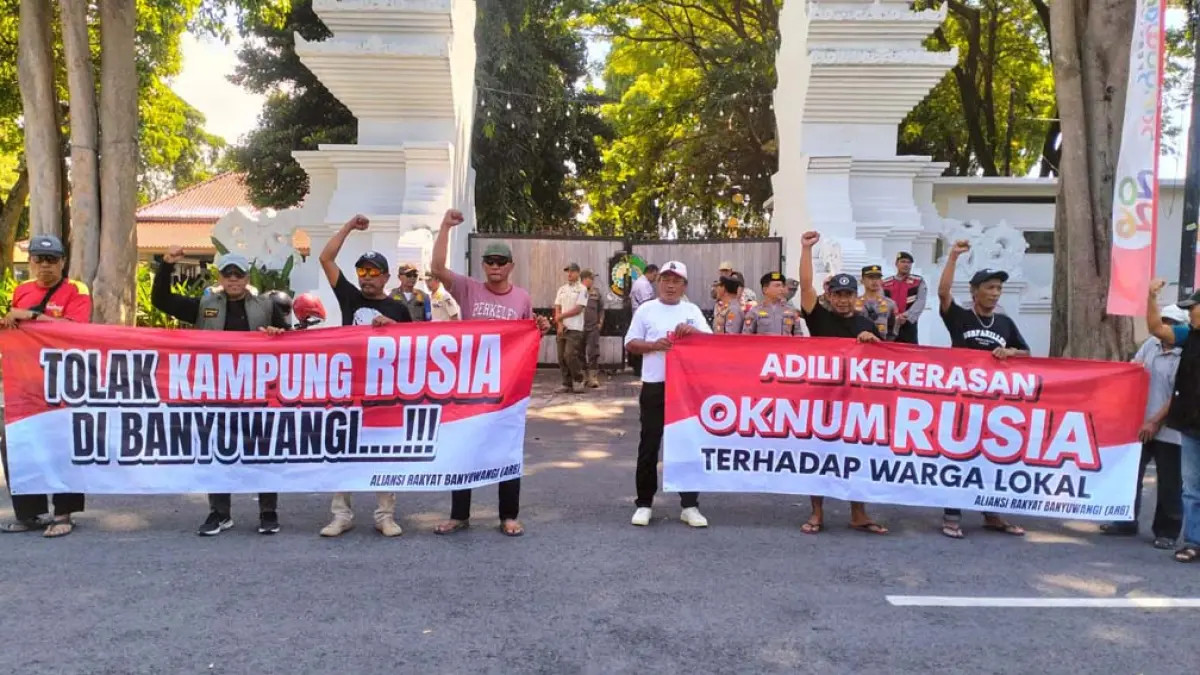 BENTANGKAN SPANDUK: Puluhan warga yang tergabung dalam LSM ARB menggelar aksi damai di depan Pendapa Sabha Swagata Blambangan, Kamis (16/4). (Bagus Rio/Radar Banyuwangi)