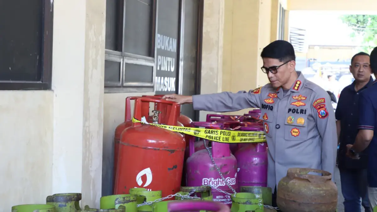 PRAKTIK CURANG: Kapolresta Banyuwangi Kombespol Rofiq Ripto Himawan didampingi Kasat Reskrim Kompol Lanang Teguh Pamudi menunjukkan barang bukti gas elpiji melon yang diinjeksi ke tabung ukuran 12 kilogram, Jumat (17/4). Pelaku menggunakan alat khusus untuk memindah gas elpiji. (Bagus Rio/Radar Banyuwangi)