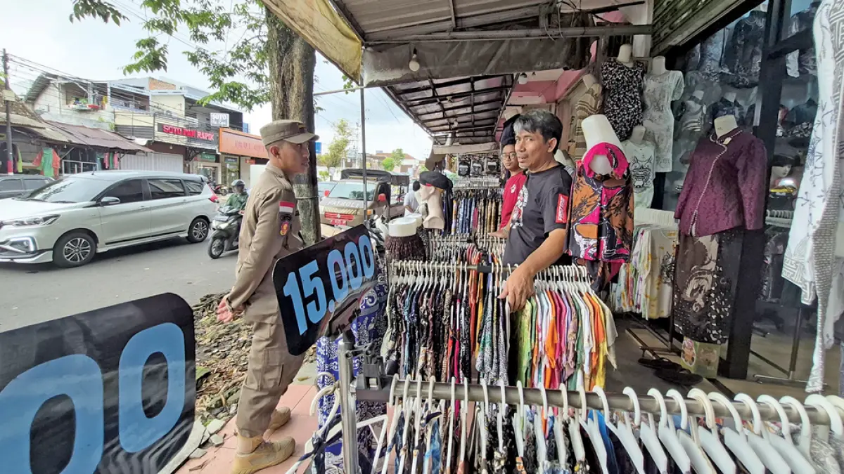 BERADAPTASI: Salah satu pedagang pakaian di Pasar Genteng 1, Desa Gentengkulon, Kecamatan Genteng, Jumat (17/4). (Salis Ali/Radar Banyuwangi)