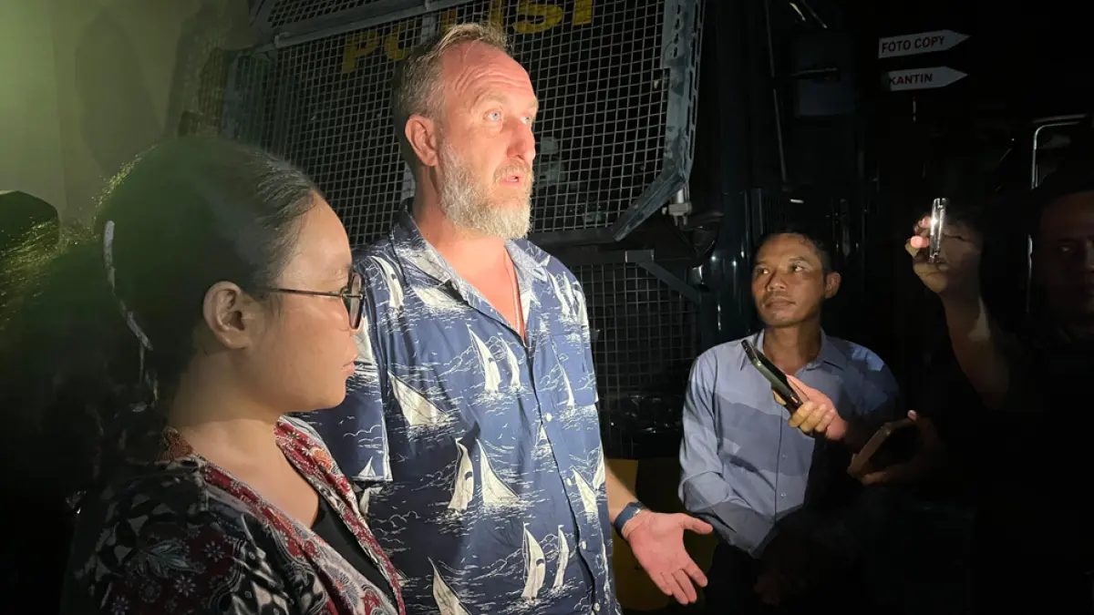 PENUHI PANGGILAN PENYIDIK: Andrew Fadeev didampingi kuasa hukumnya, Eko Sutrisno (kanan) dan penerjemah bahasa usai menjalani pemeriksaan di Mapolresta Banyuwangi, Kamis malam (16/4). (Bagus Rio/Radar Banyuwangi)