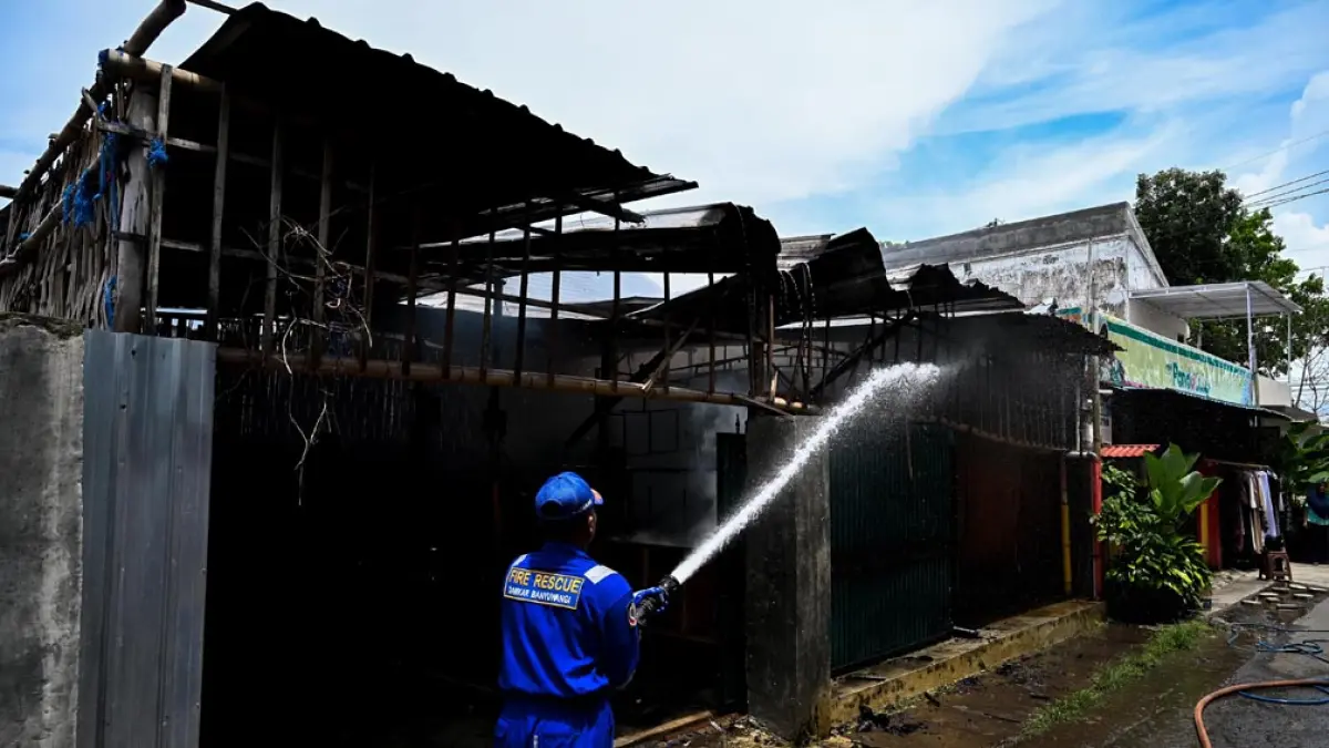 BERJIBAKU: Petugas Damkarmat menyemprotkan air ke titik api yang membakar gudang perabotan rumah tangga di Jalan Ikan Windu, Kelurahan Tukangkayu, pertengahan November 2025 lalu. (Ramada Kusuma/Radar Banyuwangi)