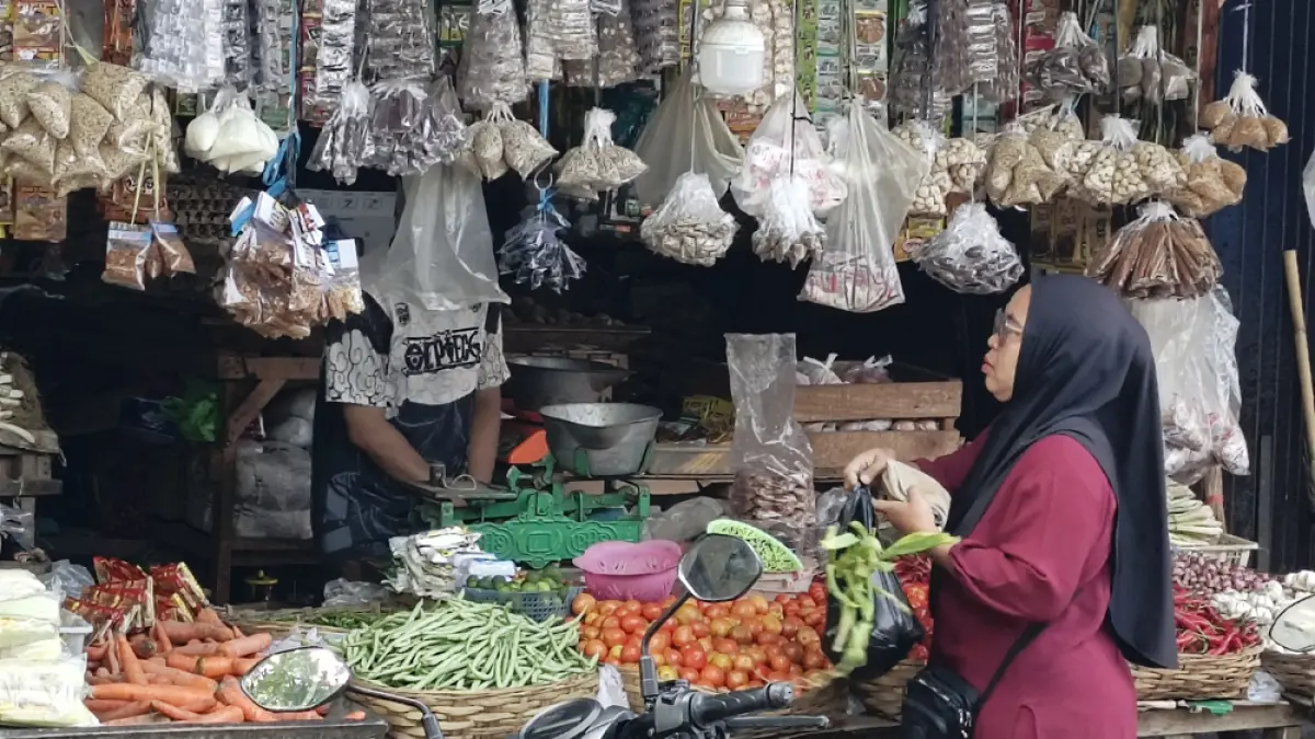 KEBUTUHAN POKOK: Pedagang dan pembeli melakukan transaksi jual beli di Pasar Blambangan, Minggu (19/4). (Ksatria Raya/Radar Banyuwangi)