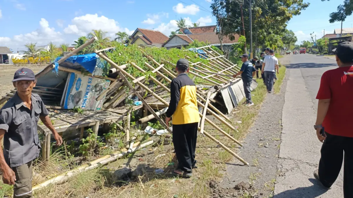 MERUSAK PEMANDANGAN: Petugas membongkar lapak UMKM yang tidak dipakai di Jalan Sumberayu, Kecamatan Muncar, Sabtu (18/4). (Slamet Hariyadi for Radar Banyuwangi)