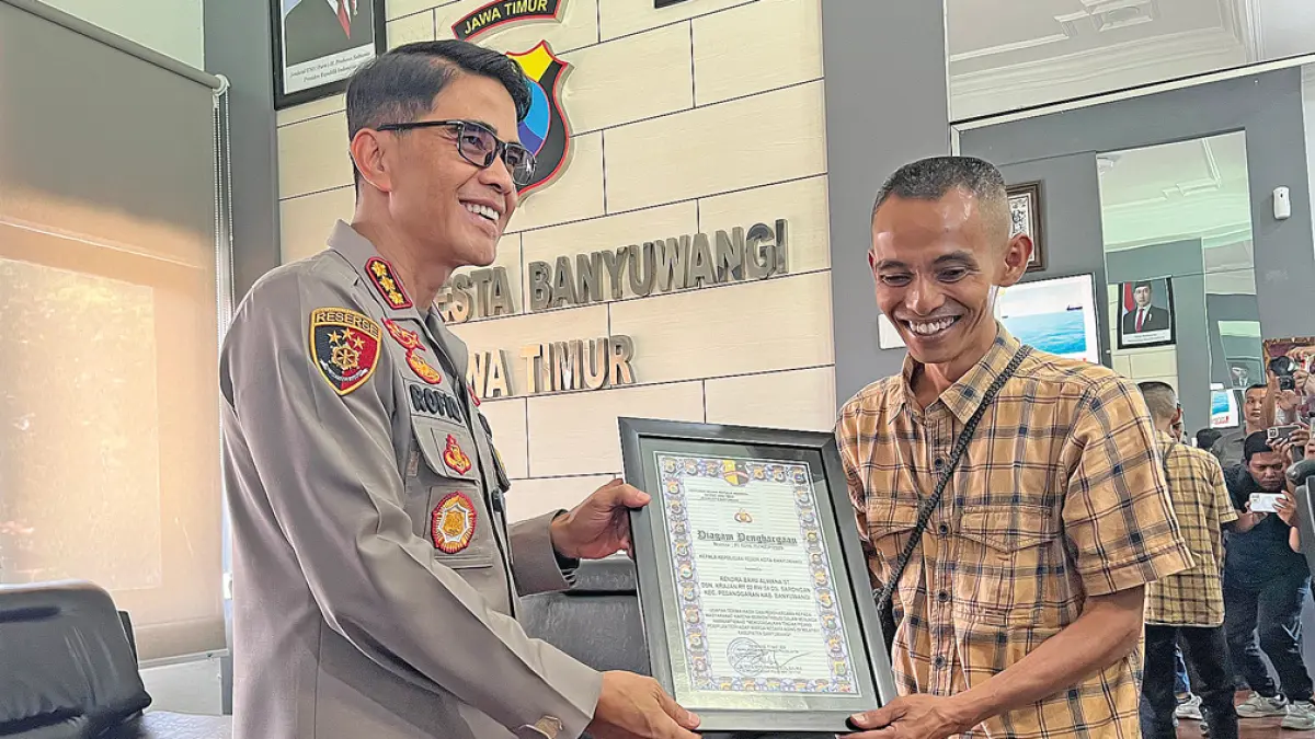 SIMBOLIS: Kapolresta Kombespol Rofiq Ripto Himawan menyerahkan penghargaan kepada Rendra Bayu Alwana di Mapolresta Banyuwangi, Minggu (19/4). (Bagus Rio/Radar Banyuwangi)
