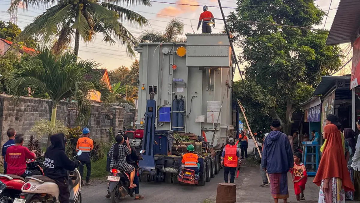 DIANGKUT TRUK: Satu unit kompomen Interbus Transformer (IBT) berkapasitas besar milik GITET Kalipuro dikawal ketat petugas setelah berhasil melewati jembatan Kalipuro, Senin (20/4) pukul 05.30. (Ramada Kusuma/Radar Banyuwangi)