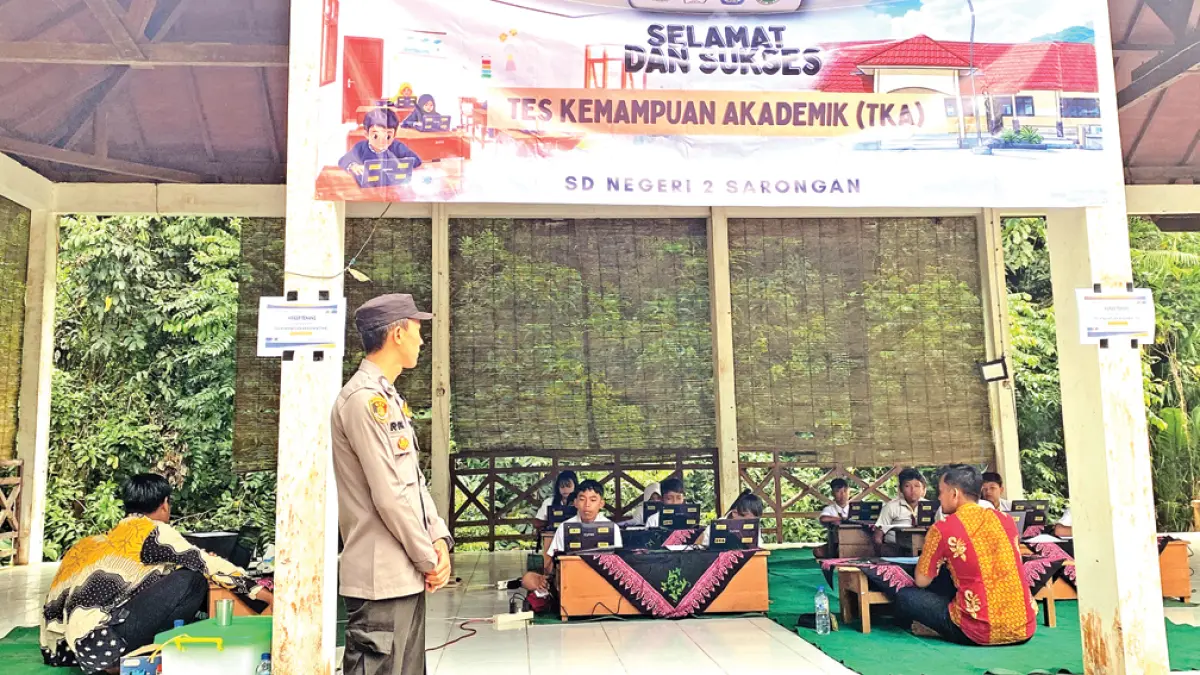 PEDULI: Bhabinkamtibmas Sarongan Briptu Robi Wijaya mengawal pelaksanaan TKA di SDN 2 Sarongan, Dusun Sukomade, Desa Sarongan, Kecamatan Pesanggaran, Senin (20/4). (Robi for Radar Banyuwangi)