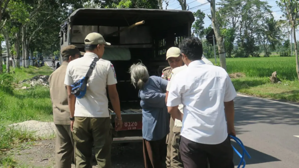 BIKIN RESAH: Petugas gabungan mengamankan ODGJ yang berkeliaran di Jalan Raya Desa Gambor, Kecamatan Singojuruh, Rabu (22/3). (Iwan Yos for Radar Banyuwangi)