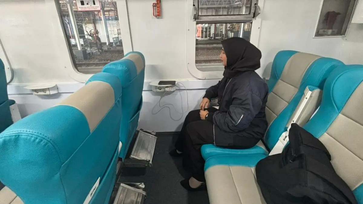 Penumpang kereta api menggunakan stop kontak di dalam kereta untuk mengisi daya. (KAI)