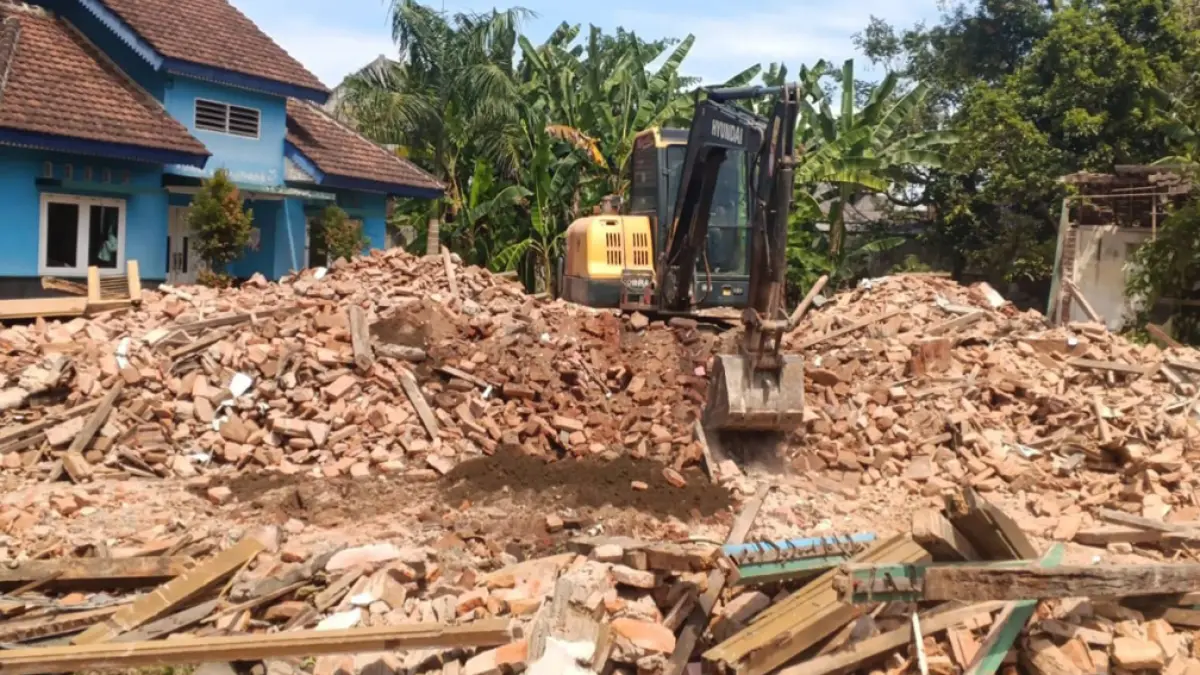 RATA TANAH: Rumah Dinas Camat Rogojampi yang terletak di sebelah barat traffic light Kluncing, Desa Lemahbangdewo dibongkar memakai alat berat, Jumat (24/4). (Teddy Radiyansyah for Radar Banyuwangi)