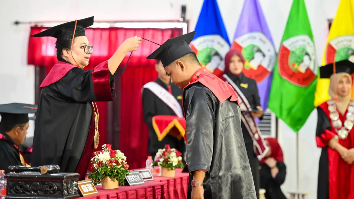 SAKRAL: Rektor Untag Banyuwangi Yovita Vivianty Indriadewi Atmadjaja saat memindahkan tali toga wisudawan. (Ramada Kusuma/Radar Banyuwangi)