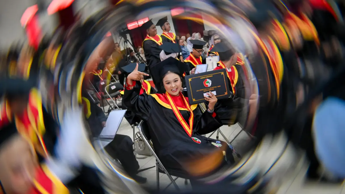 SEMRINGAH: Wisudawan menunjukkan ijazah yang diterima pada rangkaian prosesi wisuda S1 Untag Banyuwangi Sabtu (25/4). (Ramada Kusuma/Radar Banyuwangi)