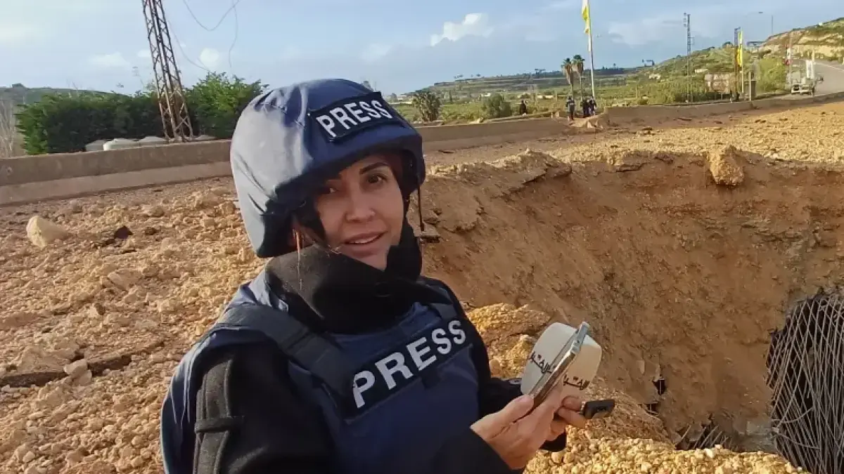Jurnalis Lebanon Amal Khalil, yang bekerja untuk surat kabar harian Al Akhbar, melaporkan di dekat jembatan yang hancur di Qasmiyeh, Lebanon, Minggu, 22 Maret 2026 [File: Mohammed Zaatari/AP Photo]