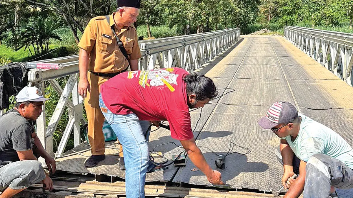 GUYUB: Petugas Kecamatan Pesanggaran bersama warga melakukan perbaikan minor Jembatan Sungailembu, Desa Sumberagung, Kecamatan Pesanggaran, Senin (27/4). (Didik for Radar Banyuwangi)