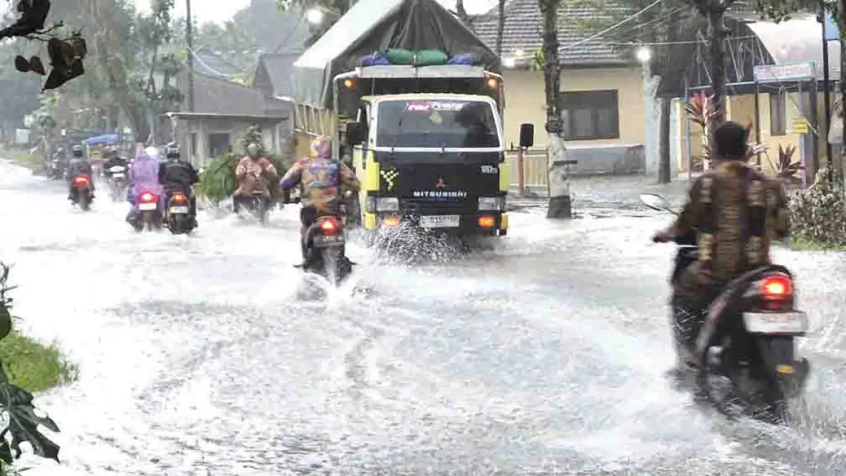 MUNCRAT: Kendaraan melintas di jalanan yang tergenang air di Dusun Krajan, Desa Genteng Wetan, Kecamatan Genteng, digenangi air, Senin sore (27/4). (Salis Ali/Radar Banyuwangi)