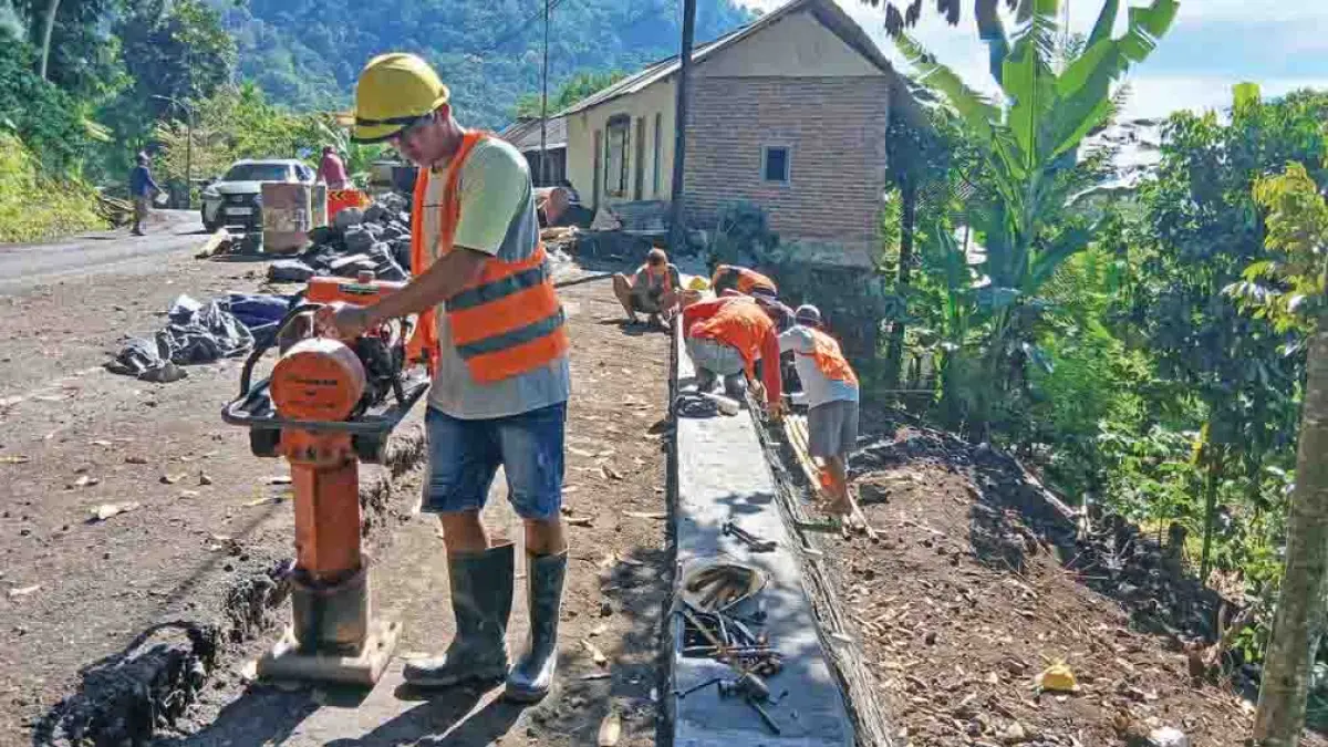 PENYELESAIAN: Pekerja melakukan pekerjaan akhir proyek perbaikan area terdampak longsor di kilometer (KM) 238 jalan raya Gunung Gumitir, Dusun Barurejo, Desa Kalibarumanis, Kecamatan Kalibaru, Selasa (28/4). (Salis Ali/Radar Banyuwangi)