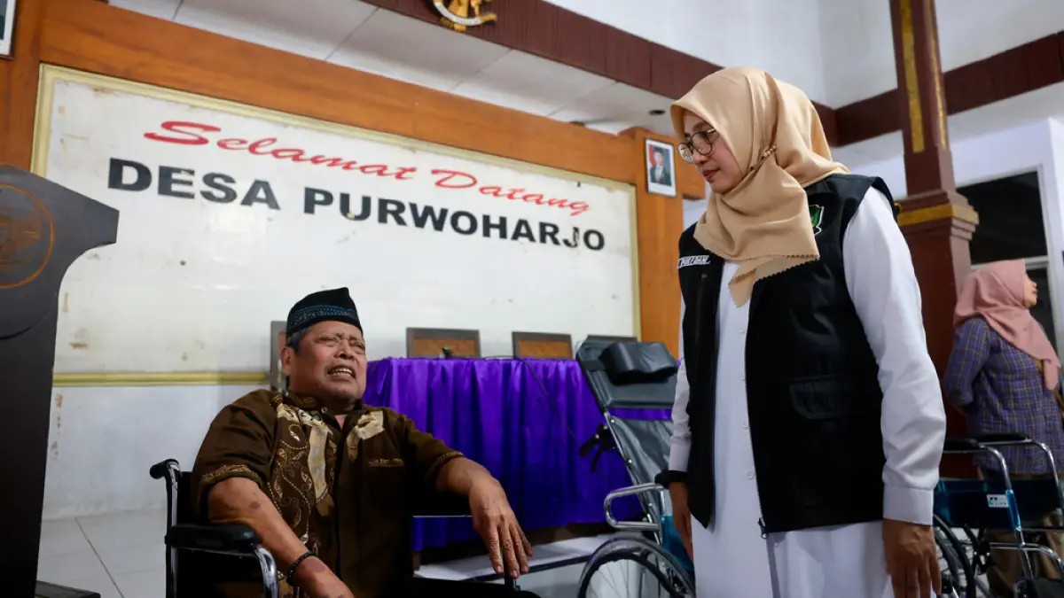 Bupati Ipuk Fiestiandani menyerahkan bantuan kursi roda kepada warga di Desa/Kecamatan Purwoharjo dalam rangkaian Bunga Desa, Rabu (29/4). (Dini for Radar Banyuwangi)
