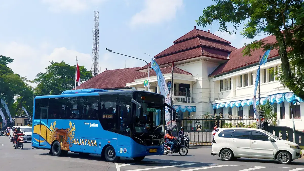 Salah satu armada Bus Trans Jatim melintas di depan Balai Kota Malang, Jumat (24/4). (Darmono/Radar Malang)
