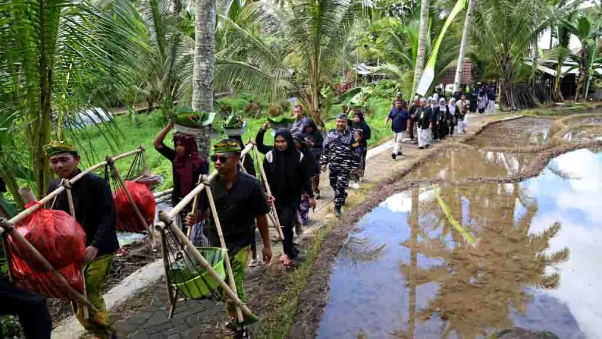 Warga suku Osing membawa wadah berisi makanan tradisional pecel ayam ke sumber mata air Mangarang saat ritual adat Ithuk-ithukan di Kampung Anyar, Rejopuro, Banyuwangi