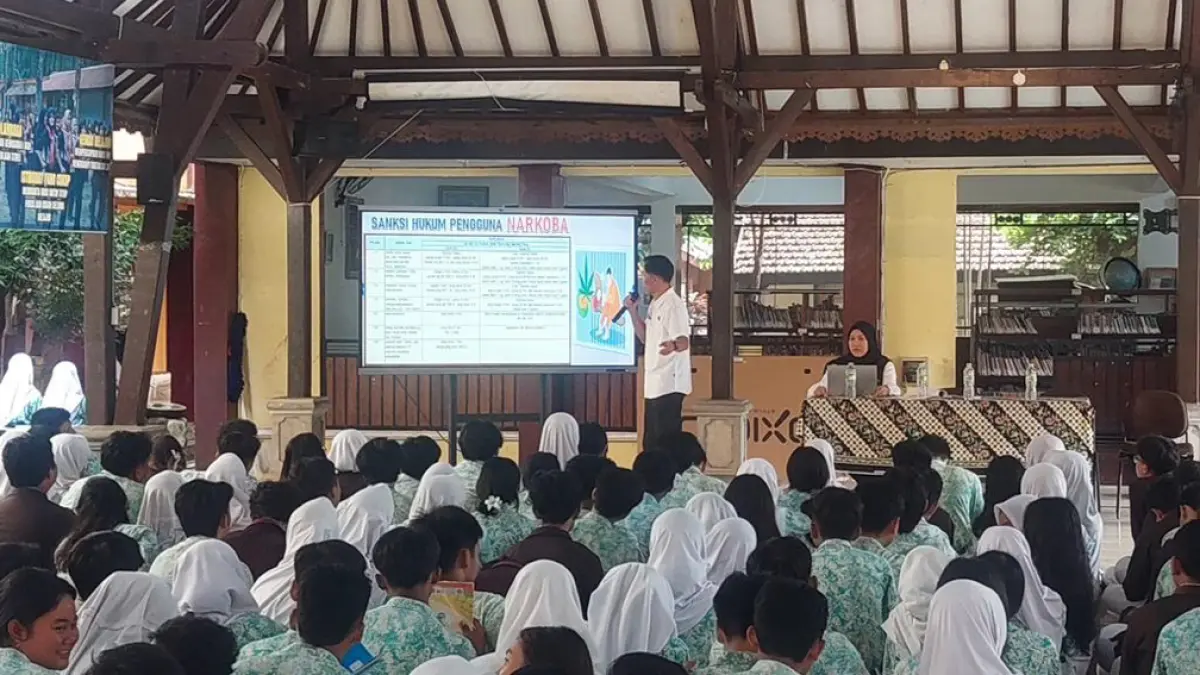 TANAMKAN KESADARAN: Personel Satnarkoba Polresta Banyuwangi menyampaikan pemaparan dampak buruk dan konsekuensi hukum penyalahgunaan narkoba kepada siswa di SMPN 1 Banyuwangi pada Kamis (30/4). (Satnarkoba Polresta Banyuwangi)