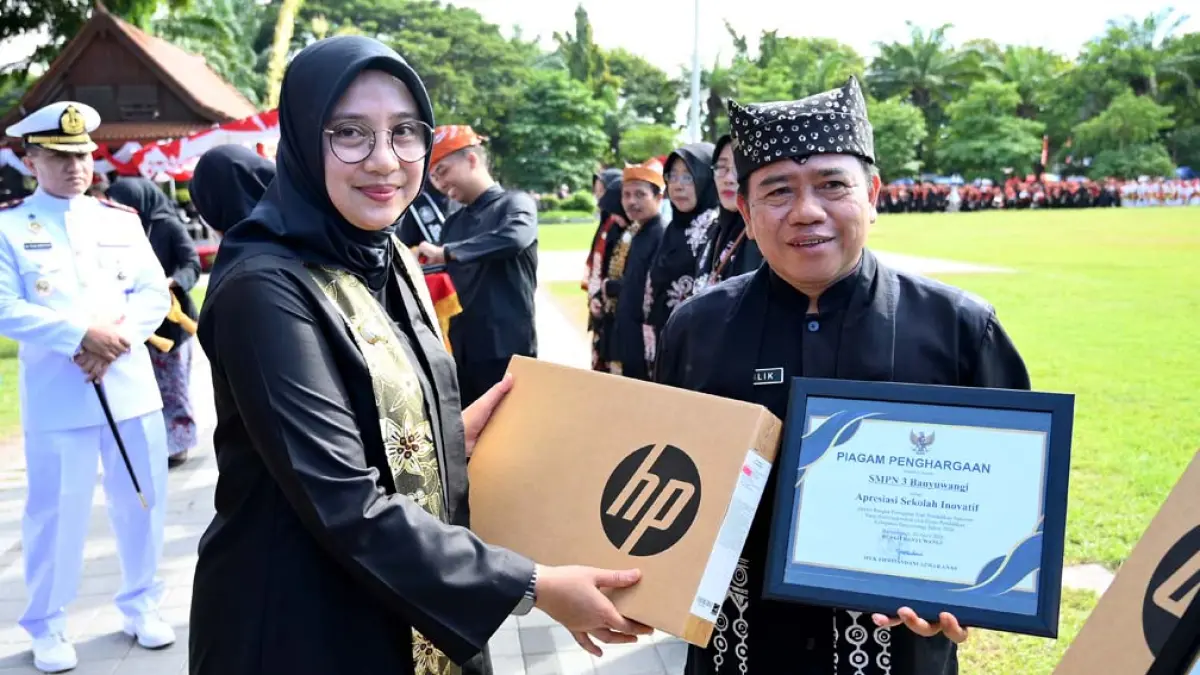 INOVASI TIADA HENTI: Bupati Ipuk Fiestiandani menyerahkan piagam penghargaan Apresiasi Sekolah Inovatif  kepada Kepala SMPN 3 Banyuwangi Holilik pada rangkaian Upacara Hardiknas 2026 di Taman Blambangan, Sabtu (2/5). (Ramada Kusuma/Radar Banyuwangi)