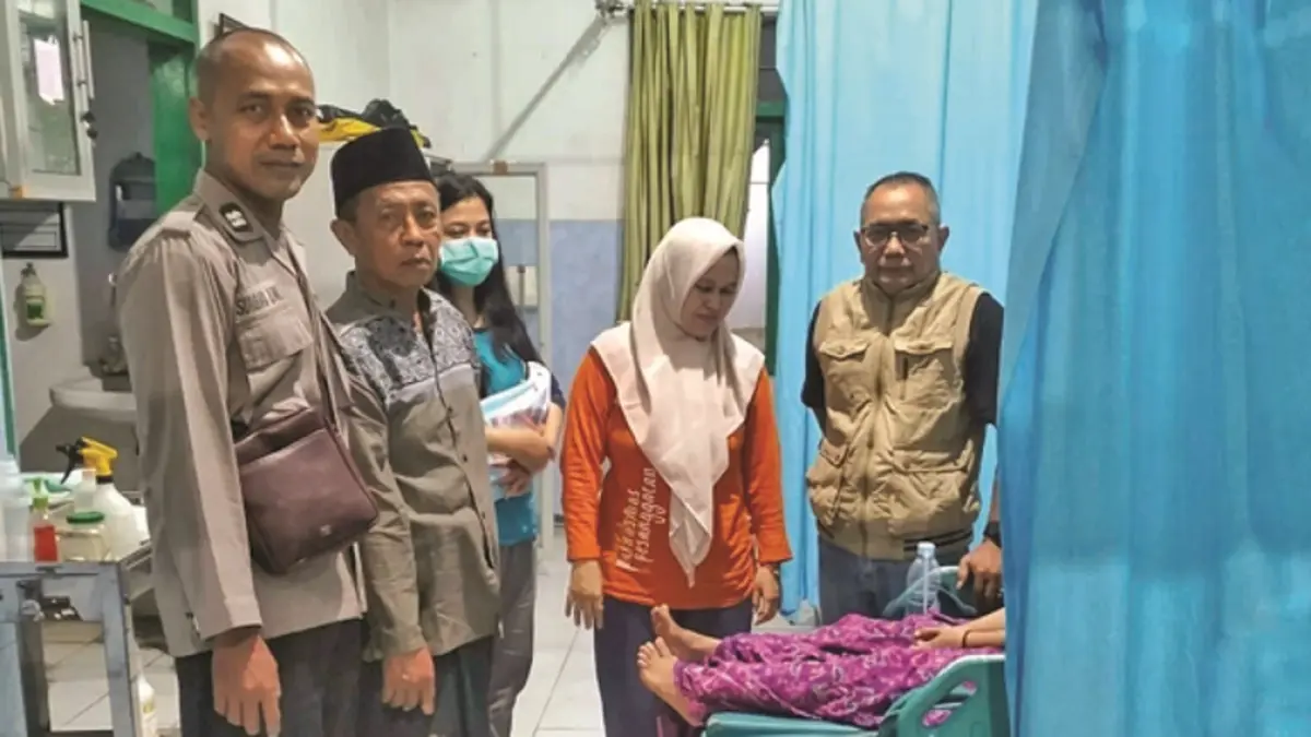 PERAWATAN MEDIS: Anggota Polsek Siliragung mengecek kondisi perempuan berinisial UDA, 25, yang berusaha melompat dari jembatan. (Dok. Polsek Siliragung)