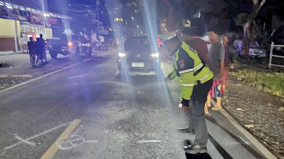 MENELAN KORBAN: Anggota Satlantas Polresta Banyuwangi memeriksa lokasi kecelakaan lalu lintas di Desa/Kecamatan Gambiran pada Senin malam (4/5). (Pepri Alvian for Radar Banyuwangi)