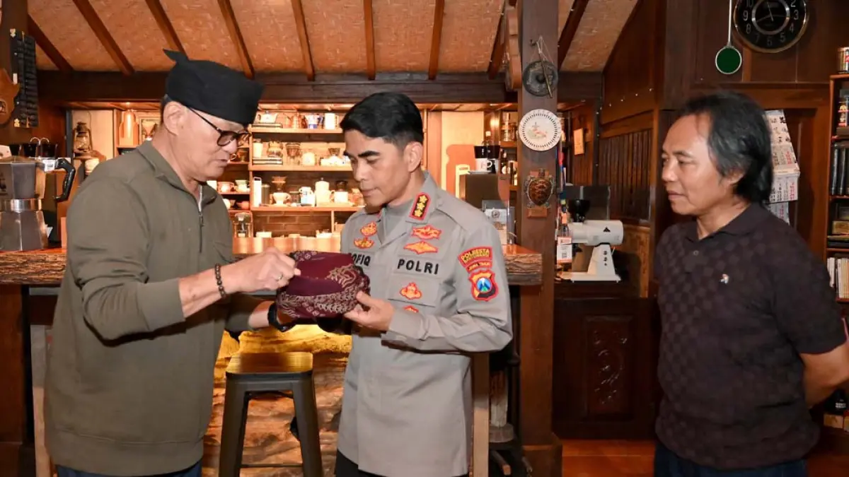 Tester kopi internasional Setiawan Subekti menyerahkan udeng kepada Kapolresta Kombespol Rofiq Ripto Himawan didampingi Direktur Radar Banyuwangi Samsudin Adlawi di Sanggar Genjah Arum, Desa Kamiren, Jumat (1/5). (Ramada Kusuma/Radar Banyuwangi)