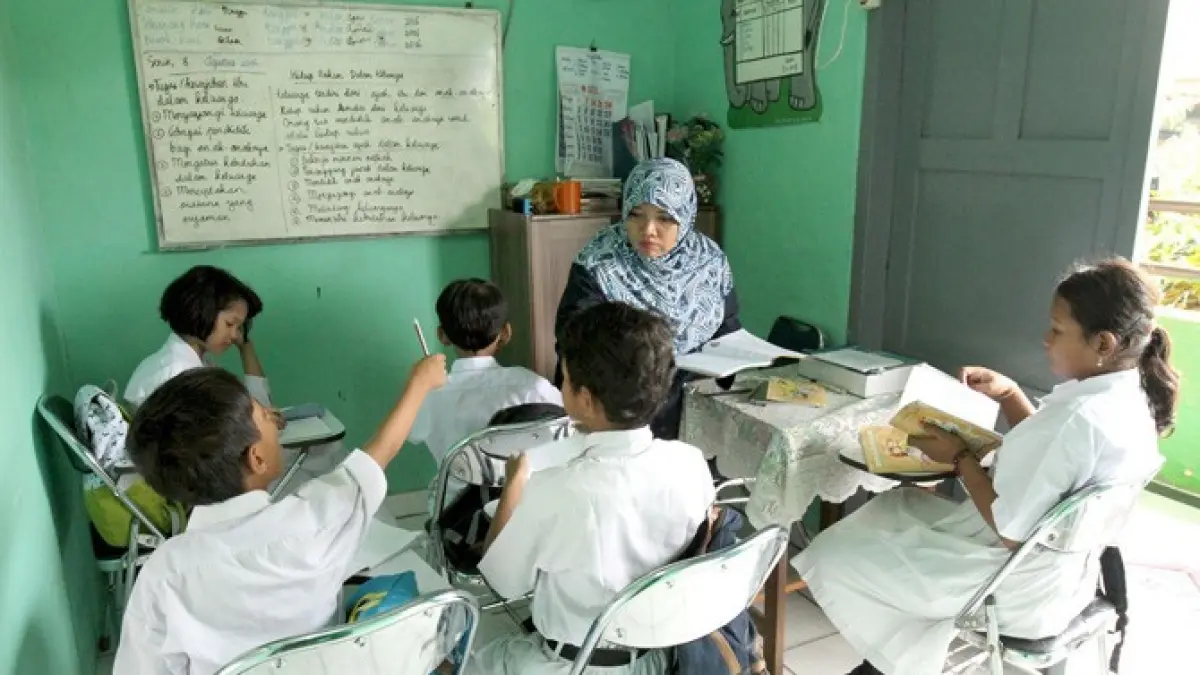 Seorang guru dan dan beberapa murid saat kegiatan belajar mengajar di Jakarta. (JawaPos.com)