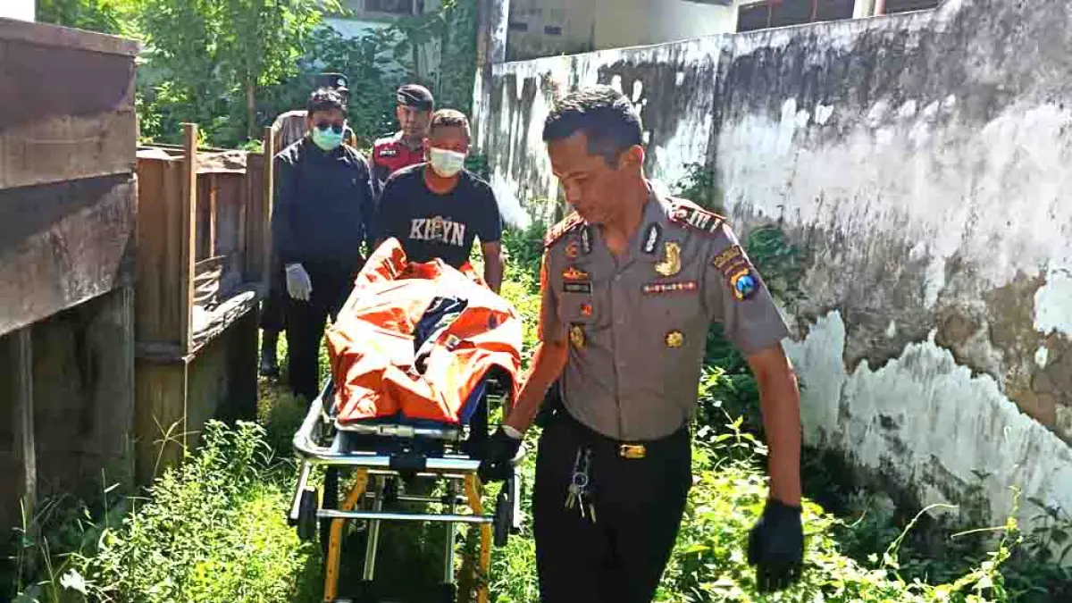 DIEVAKUASI: Kapolsek Banyuwangi AKP Hendri Christanto mengevakuasi jenazah Sulamto HS, 75, yang ditemukan tak bernyawa di belakang Kantor MUI Banyuwangi, Kamis (7/5). (Polsek Banyuwangi)