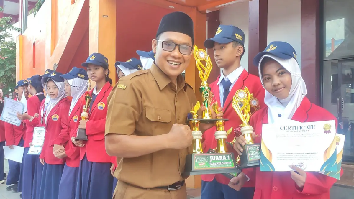 KAYA PRESTASI: Kepala SMPN 1 Genteng Ali Mustofa menyerahkan piala penghargaan sejumlah siswa berprestasi, Senin (4/5). (GITA for Radar Banyuwangi)
