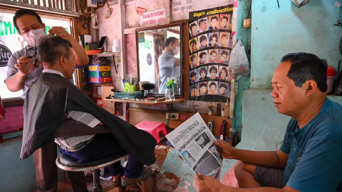 BUKA SEJAK 2024: Pangkas rambut Roy yang beralamat di dekat kuburan bendo Pengantigan cukup laris.  Sehari, Roy bisa melayani sekitar 20 pelanggan. (Ramada Kusuma/Radar Banyuwangi)