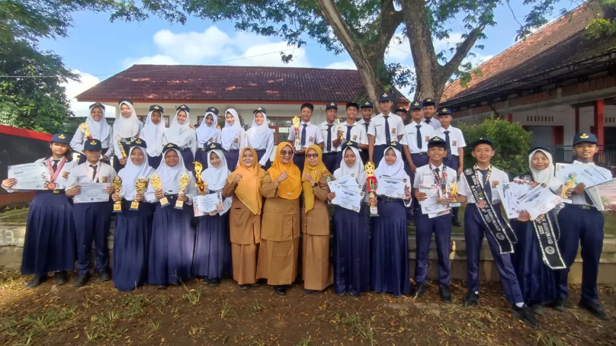 SANG JUARA: Puluhan siswa SMPN 1 Cluring peraih prestasi berfoto bersama kepala sekolah, Sri Wahyu Prihatain (tengah, berkacamata). (Sri Wahju Prihatin for Radar Banyuwangi)