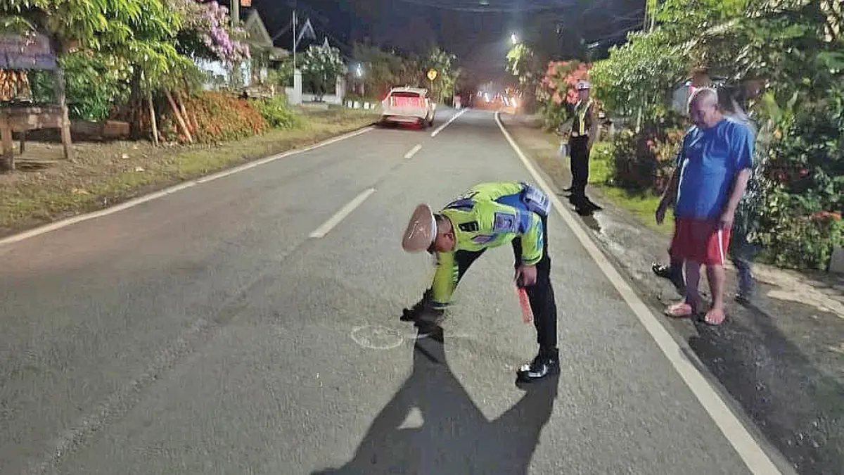 TEMPAT KEJADIAN: Anggota lantas Polresta Banyuwangi menandai lokasi kecelakaan lalu lintas antara sepeda motor dengan mobil di Jalan Raya Desa Kepundungan, Kecamatan Srono, Minggu malam (10/5). (Pepri Alvian for Radar Banyuwangi)