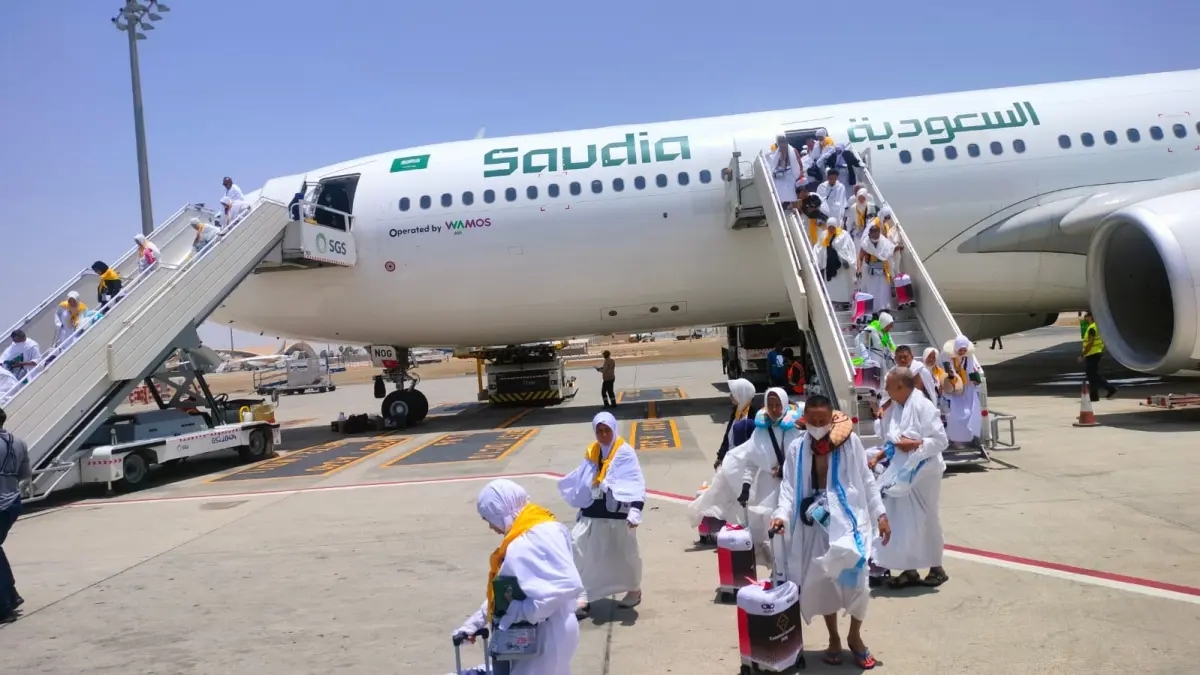 MENDARAT MULUS: Begitu turun dari tangga pesawat di Jeddah, jemaah kloter 85 banyak yang terharu. (Khoirul Muklis for Radar Banyuwangi)