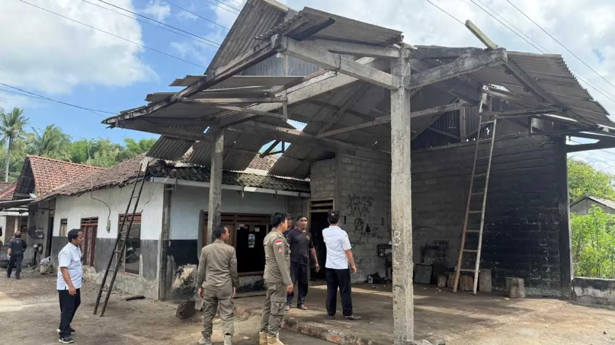 PENINJAUAN: Petugas Kecamatan Bangorejo meninjau bengkel yang rusak akibat diterjang angin kencang di Desa Temurejo, Kecamatan Bangorejo, Rabu (13/5). (Khoirul Anam for Radar Banyuwangi)
