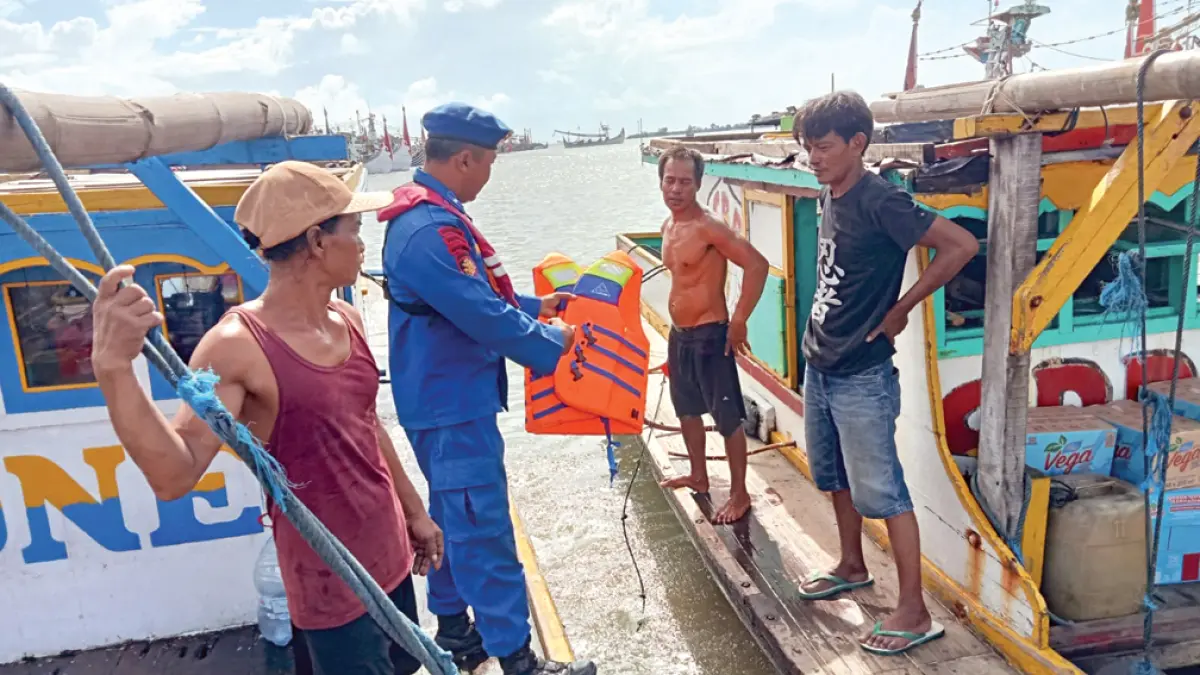 HUMANIS: Kanit Satpolairud Muncar Aipda Wayan Wedhana menyampaikan imbauan kepada nelayan untuk lebih memperhatikan faktor keselamatan melaut di area Pelabuhan Muncar, Jumat (15/4). (Zamrozi Wahyu/Radar Banyuwangi)