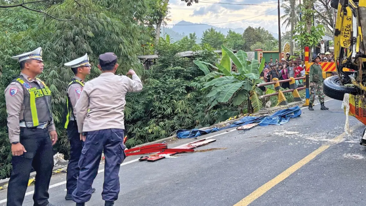 TKP: Petugas Unit Lantas Polsek Kalibaru saat mengecek TKP truk bermuatan buah melon yang menabrak pembatas jembatan di Jalan Raya Jember, Desa Tulungrejo, Kecamatan Glenmore, Rabu pagi (13/5). (Salis Ali/Radar Banyuwangi)