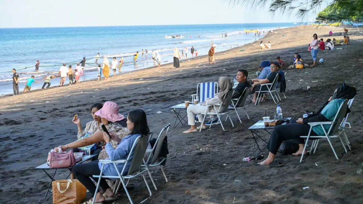 TEDUH: Pengunjung menikmati suasana sore di pantai Pulau Santen sembari menikmati kuliner. Ada yang sekadar duduk-duduk di kursi sembari melihat pemandangan laut. (Ramada Kusuma/Radar Banyuwangi)