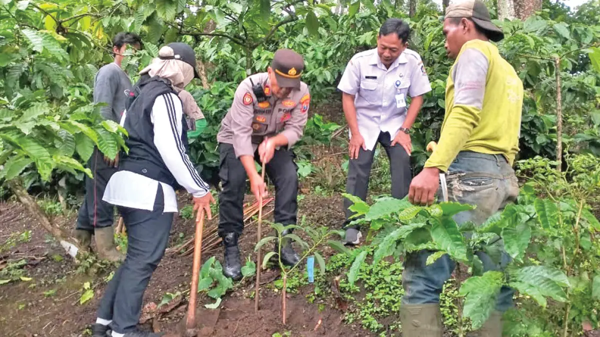PENGHIJAUAN: Jajaran kepolisian, perwakilan desa, hingga petugas Perhutani melakukan penanaman pohon buah di lereng gunung Gumitir, Sabtu (16/5). (Arif for Radar Banyuwangi)