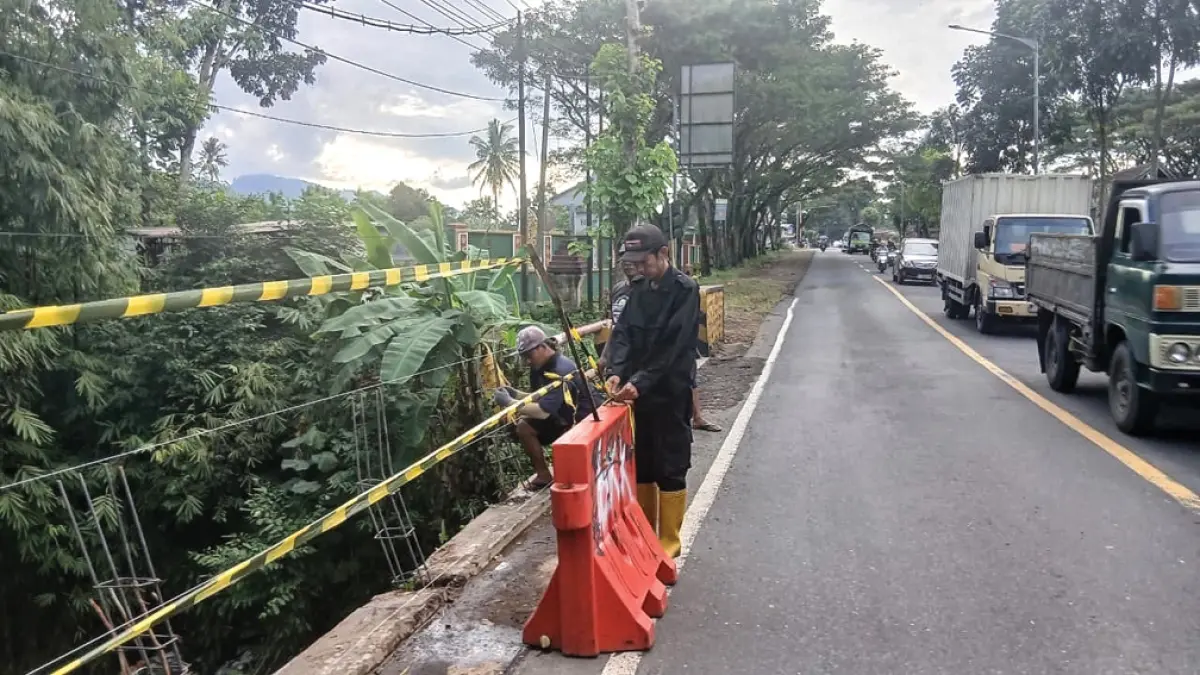 PERBAIKAN: Petugas mulai memperbaiki pembatas jembatan di timur Pasar Hewan Desa Tulungrejo, Kecamatan Glenmore, Sabtu (16/5). (Wiji for Radar Banyuwangi)