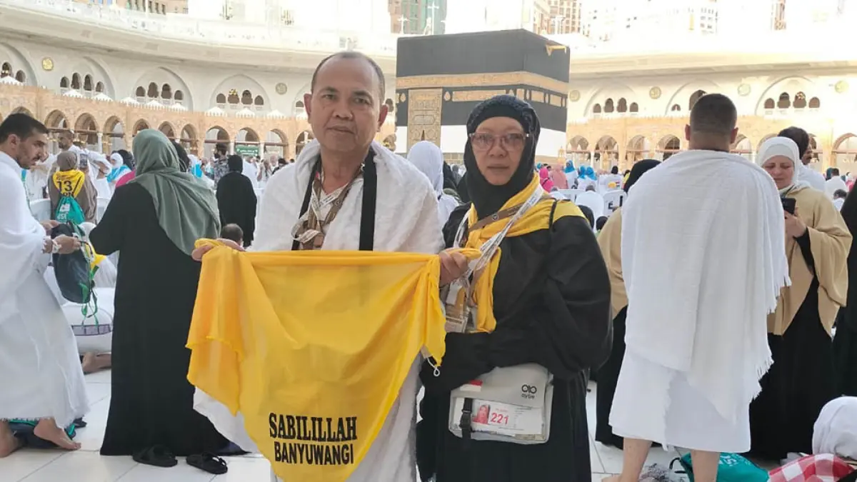 Pasangan suami istri asal Banyuwangi, Jaeno dan Suratmini, yang tergabung dalam KBIHU Sabilillah Banyuwangi berada di depan Kakbah. (Dok. KBIHU Sabilillah)