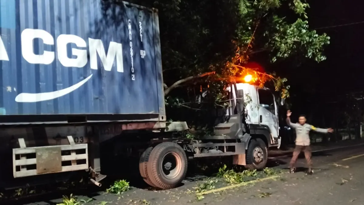 TURUN JALAN: Anggota Polsek Cluring mengatur alur lalu lintas di lokasi tronton tabrak ranting pohon di Dusun Kepatihan, Desa/Kecamatan Cluring Senin malam (18/5). (Putu Ardana for Radar Banyuwangi)