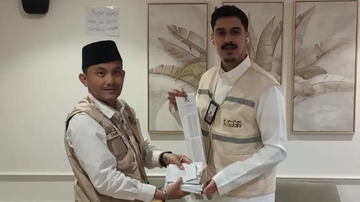 TUNAI: Ketua Kloter 85 Taufik Siradj (kiri) menyetorkan uang dam haji Tammattu kepada lembaga Adohi, di Makkah, Selasa (19/5). (Taufik Siradj for Radar Banyuwangi)
