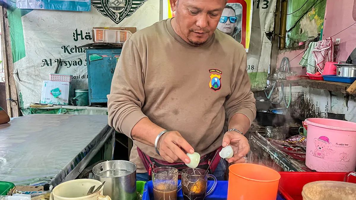 GENERASI KEDUA: Ismail meracik kopi jahe telur bebek yang menjadi menu favorit warung Bang Ali yang lokasinya di sebelah utara Apotek Kimia Farma Jalan Basuki Rahmad, Kelurahan Singotrunan, Jumat (22/5). (Ramada Kusuma/Radar Banyuwangi)