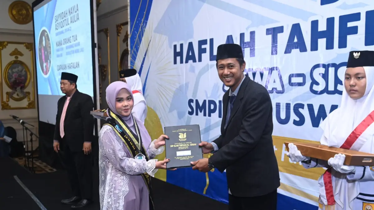 Ustad Area Sabath Zafatah, Kepala Sekolah SMPIT Al Uswah Banyuwangi memberikan ijazah kepada siswi SMPIT Al Uswah. (Ramada Kusuma/Radar Banyuwangi)