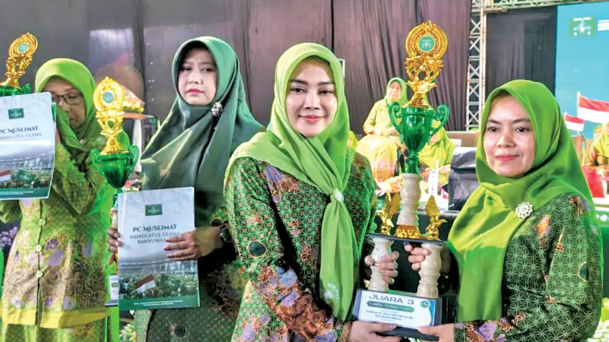 PENGANUGERAHAN PEMENANG: Pengawas koperasi An Nisaa Muslimat NU Banyuwangi Hj Desi Prakasiwi menyerahkan piala kepada pemenang lomba hadrah dalam puncak peringatan HUT ke-80 Muslimat NU di Banyuwangi Park, Minggu (24/5). (Ksatria Raya/Radar Banyuwangi)