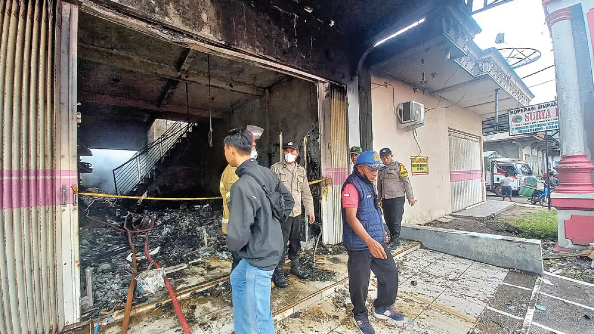 OLAH TKP: Anggota Polsek Tegaldlimo melakukan pemeriksaan di toko elektronik di Desa Purwoasri, Kecamatan Tegaldlimo, yang terbakar, Kamis (28/5). (Sadimun for Radar Banyuwangi)