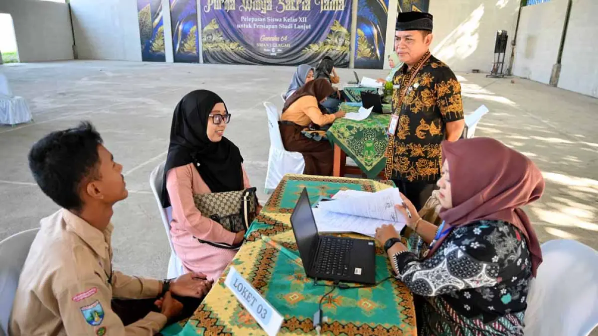 PASTIKAN LANCAR: Kepala SMAN 1 Glagah Abdullah memantau langsung proses pengambilan PIN SPMB di taman sekolah setempat, Jumat (29/6). (Ramada Kusuma/Radar Banyuwangi)